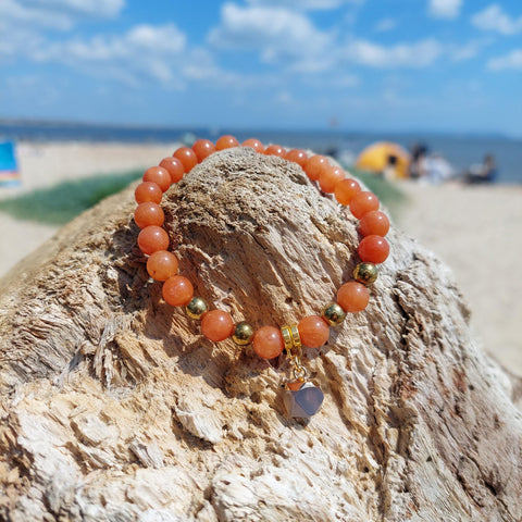 Gorgeous handmade 8mm deep orange natural stone quartz beaded bracelet with gold plated dark grey hexagon natural stone charm ﻿Elasticated, so will fit most adult wrists (measuring 71/2 in/19cm) Lovely gift for friends or family **Presented in lovely Kraft paper gift box with reusable organza pouch*