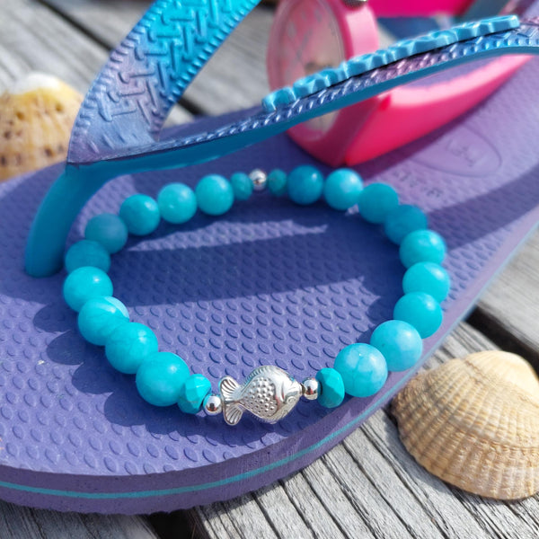 Gorgeous 8mm Sea Blue Matt Beads with Sterling Silver Beads &amp; Cute Fish Charm  Elasticated, so will fit most adult wrists (measuring 7.5 in/19cm)   Add a cool beach vibe look to your outfit&nbsp;  **Presented in lovely Kraft paper gift box with reusable organza pouch**