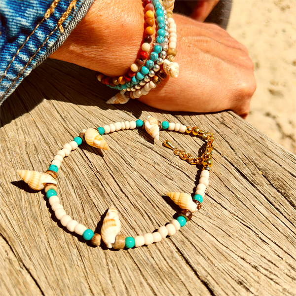 Ivory seed beads, turquoise calcite, coconut discs &amp; little spiral shells  Each anklet has gold plated fastenings &amp; lobster clasp with star charm  Length - 24cm extends to 251/2cm  Perfect gift for any surf chick!  **Presented in lovely Kraft paper gift box with reusable organza pouch**