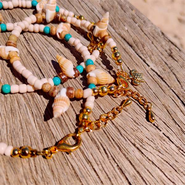 Ivory seed beads, turquoise calcite, coconut discs &amp; little spiral shells  Each anklet has gold plated fastenings &amp; lobster clasp with star charm  Length - 24cm extends to 251/2cm  Perfect gift for any surf chick!  **Presented in lovely Kraft paper gift box with reusable organza pouch**